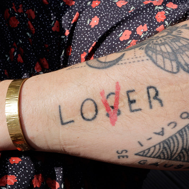 Lover  loser lettering tattoo located on the neck